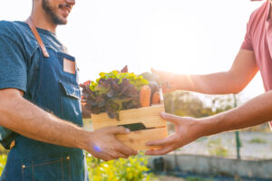 Two people exchanging a box of produce at one of the farms on Martha's Vineyard.